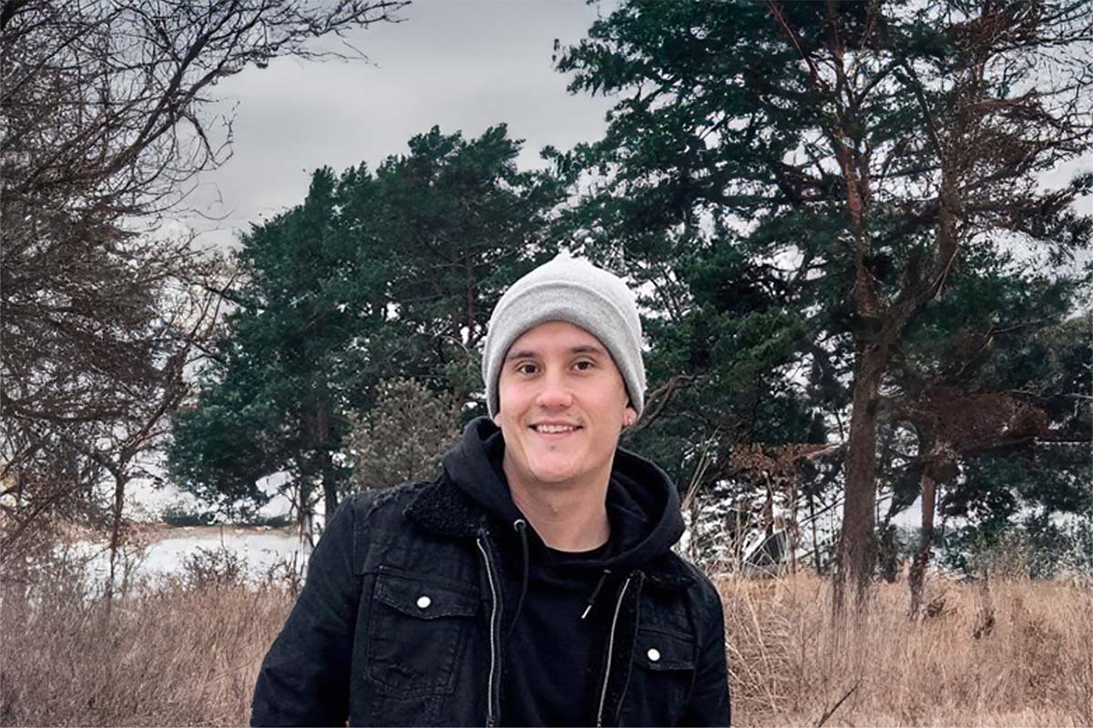 Porträt eines jungen Mannes mit Mütze vor herbstlicher Küstenkulisse, positives Gastfeedback zur Arkona Sky Bar.