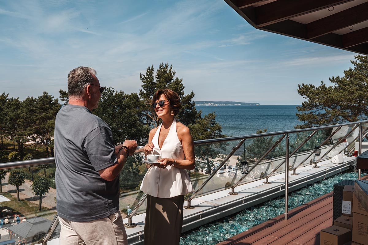 Paar bei Kaffee auf der Terrasse der Sky Bar in Binz auf Rügen mit Blick über die Ostsee.